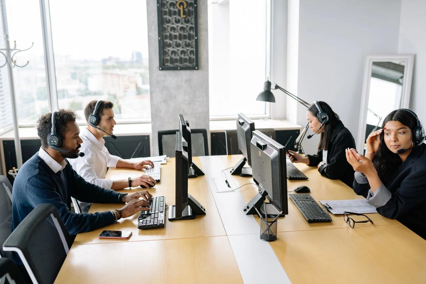 Personas atendiendo consultas con auriculares en una oficina