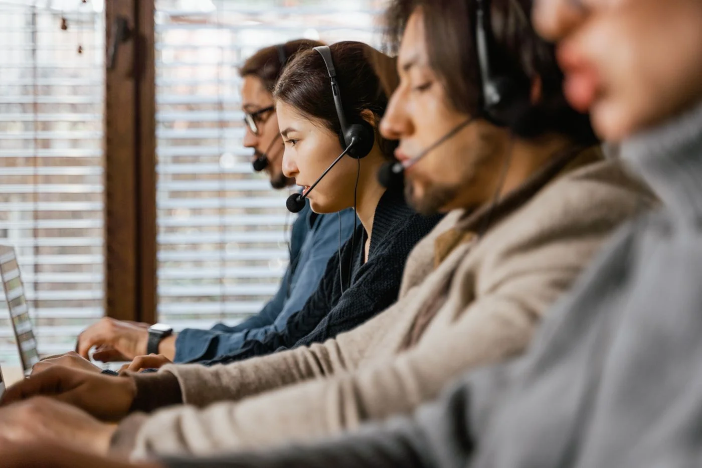 Personas atendiendo consultas con auriculares y ordenadores